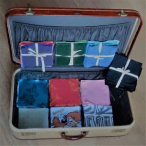 Valise pleine de carrés de tissu de toutes les couleurs, avec ou sans motifs, pour un atelier créatif